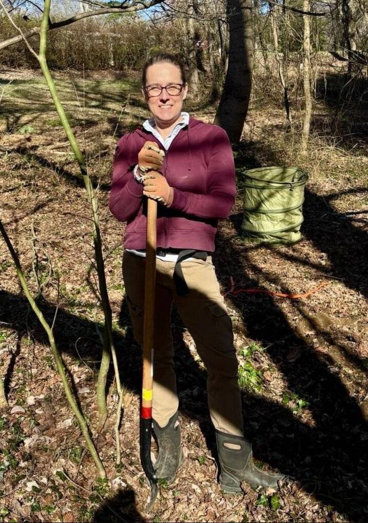 Elizabeth Hamilton holding a shovel in the McCoy woods