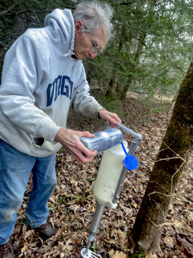 Joe Davis measures imidacloprid to treat a hemlock tree