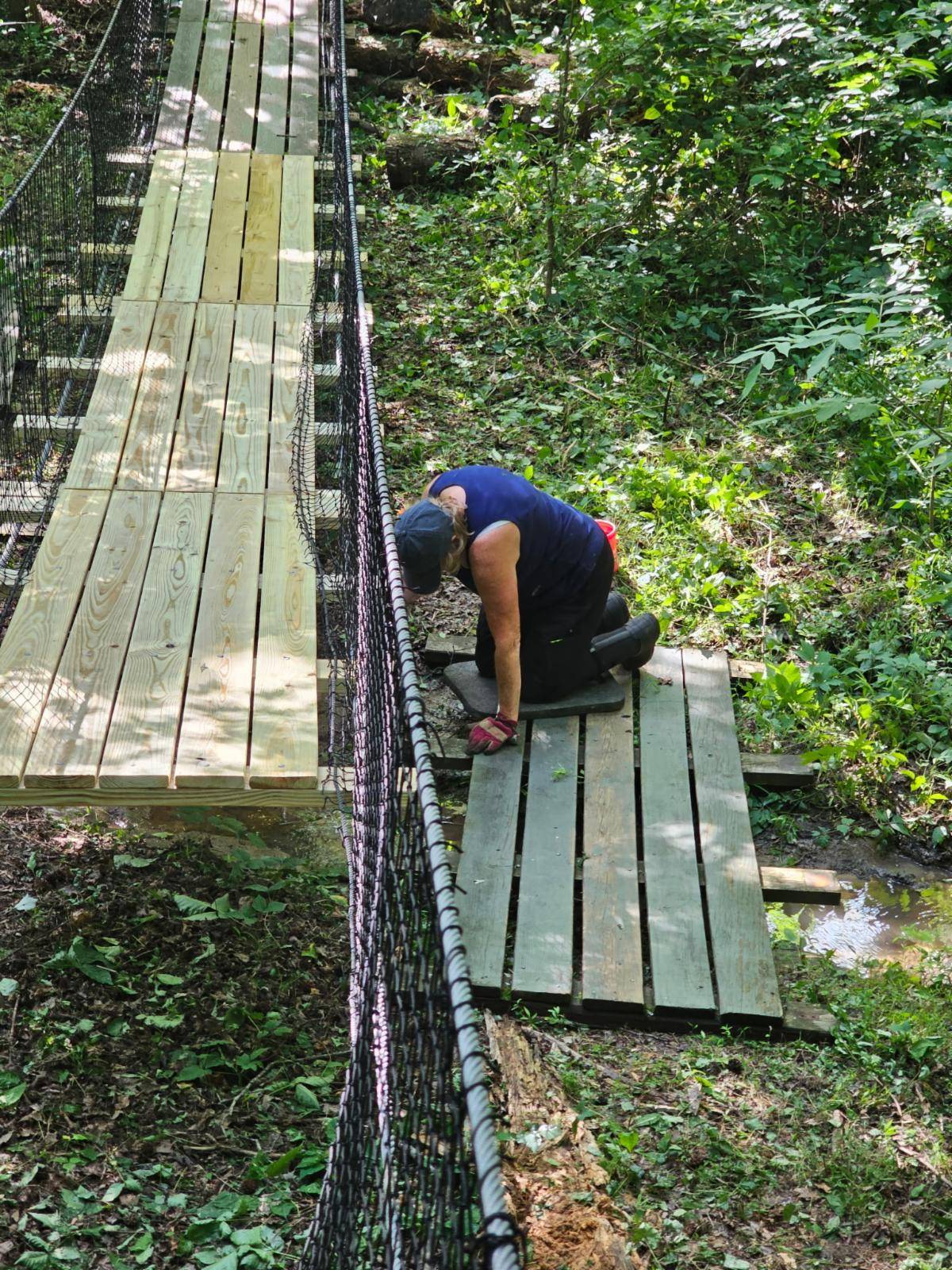 Grounds Group volunteer working on the trail bridge planks